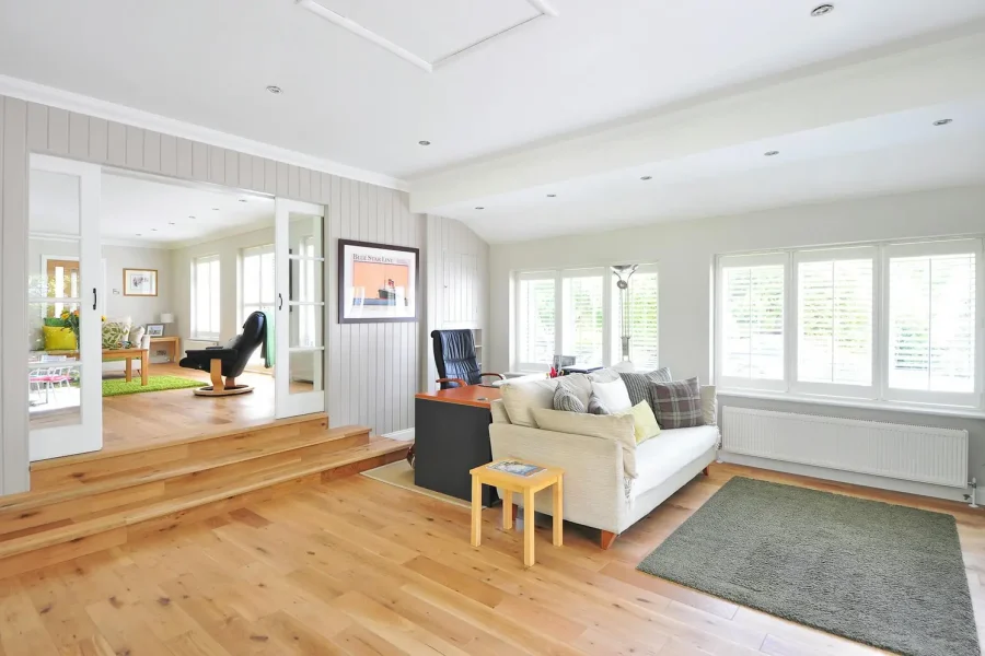 Sunken living room with a wide set of sliding doors, leading up three steps to an elevated area of the home.