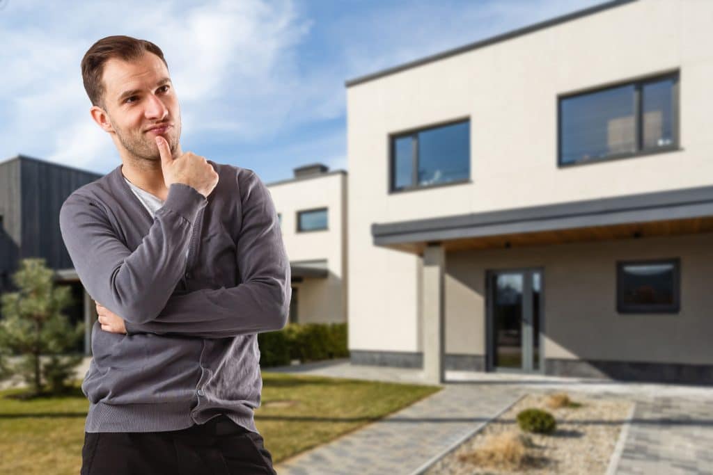 Man standing in front of modern house.