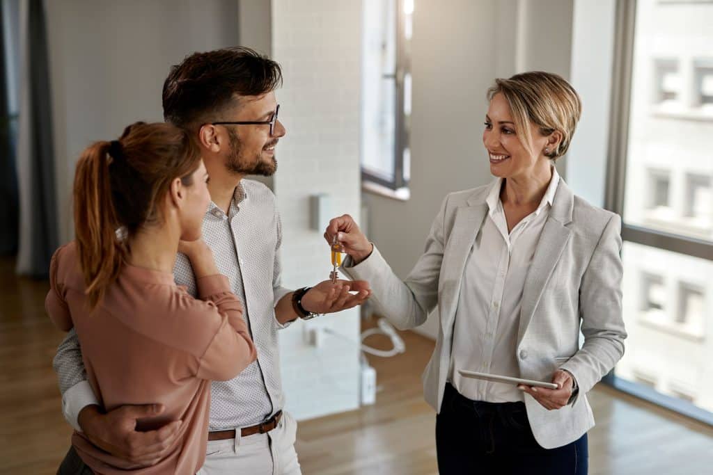 Agent handing over keys to buyers.