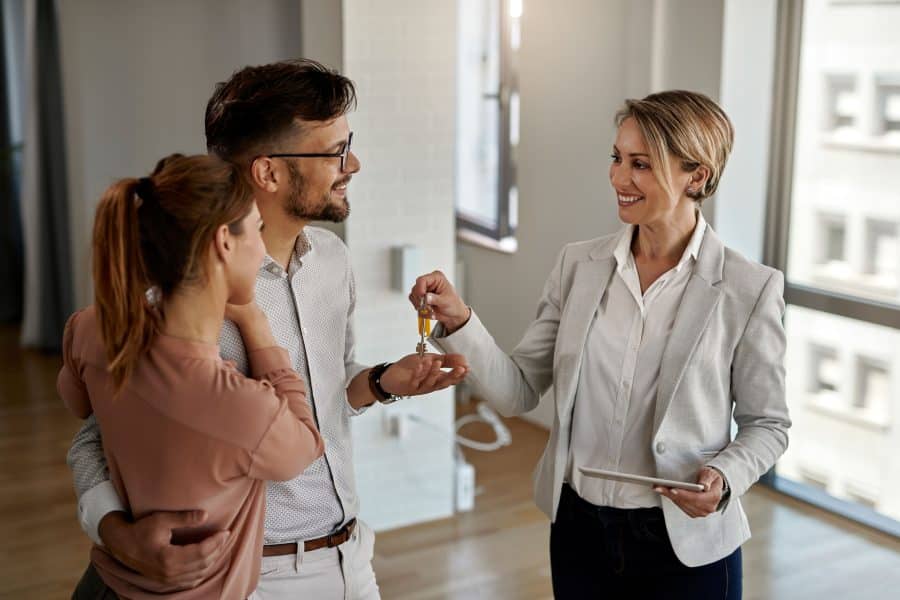 Agent handing over keys to buyers.