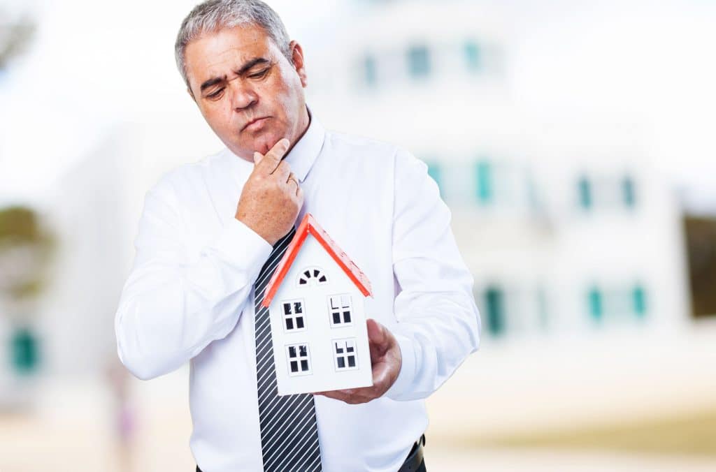 Man holding a small house model.