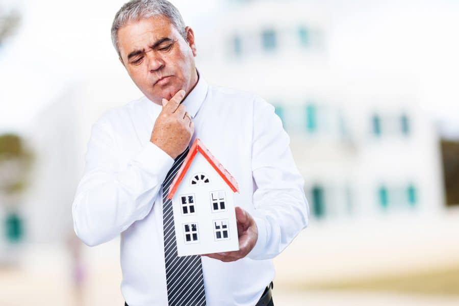 Man holding a small house model.